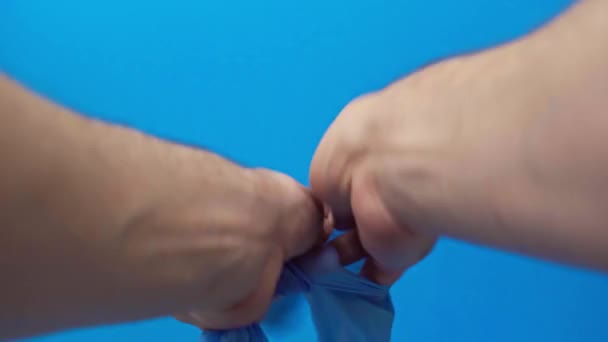 Обрезанный Вид Человека Надевая Латексные Перчатки Изолированы Синий Covid Концепции — стоковое видео