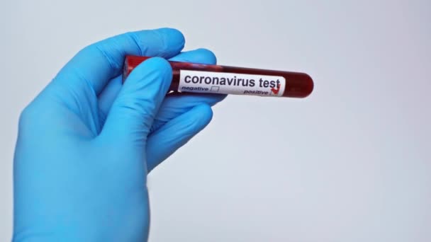 灰色で隔離された陽性のコロナウイルス検査を保持している医師のクロップドビュー — ストック動画
