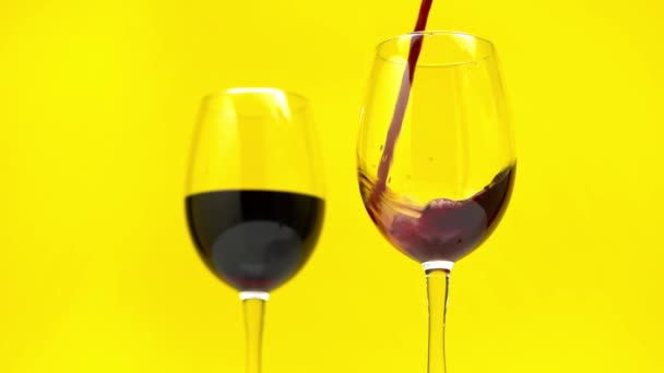 红葡萄酒倒入与黄色隔离的玻璃杯的慢动作 — 图库视频影像