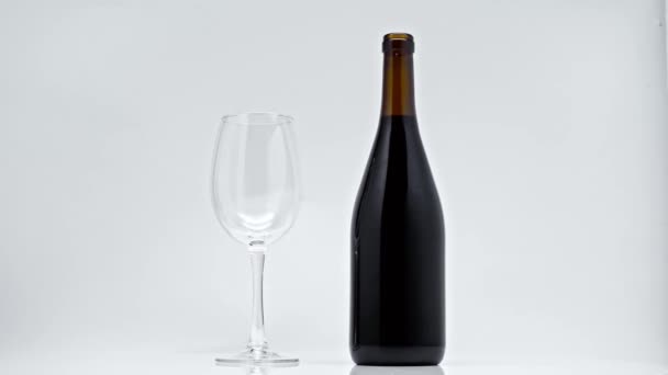 Schwarze Flasche Und Glas Drehen Sich Auf Grau — Stockvideo