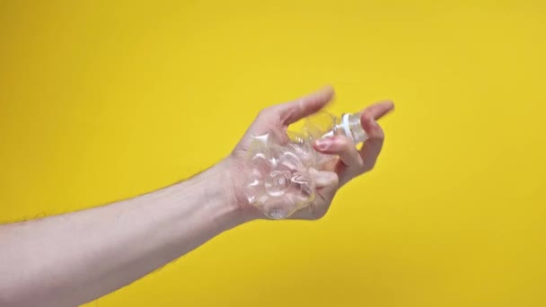 Hiperlapso Homem Crumpling Garrafa Plástico Isolado Amarelo — Vídeo de Stock