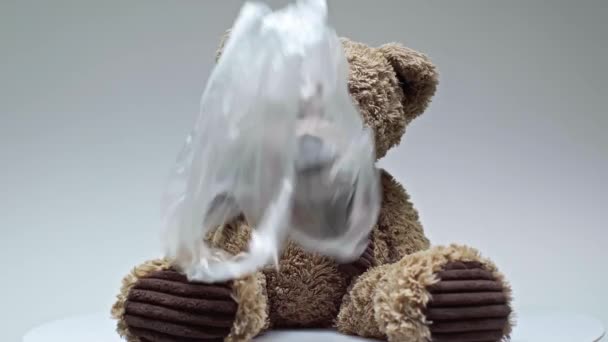 Abgeschnittene Ansicht Von Plastiktüten Fallen Auf Teddybär Auf Grau — Stockvideo