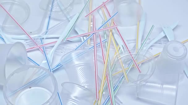 Vasos Plástico Cayendo Sobre Tenedores Pajitas Sobre Blanco — Vídeos de Stock