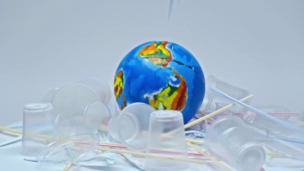 Plastic Bekers Vallen Wereldbol Buurt Van Afval Wit — Stockvideo
