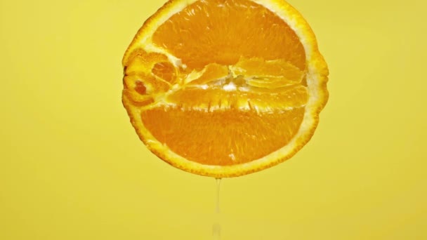 Gotas Jugosas Goteando Naranja Medio Aislado Amarillo Cámara Lenta — Vídeo de stock