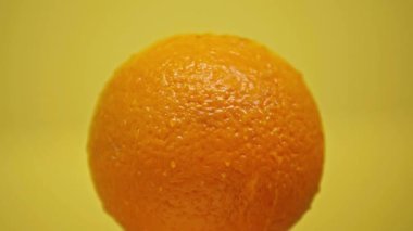 Olgun turuncu üzerine düşen damlalar sarı üzerine izole edilmiş.