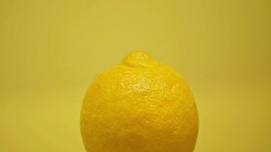 Olgun limonun üzerine düşen damlalar sarı üzerine izole edilmiş.