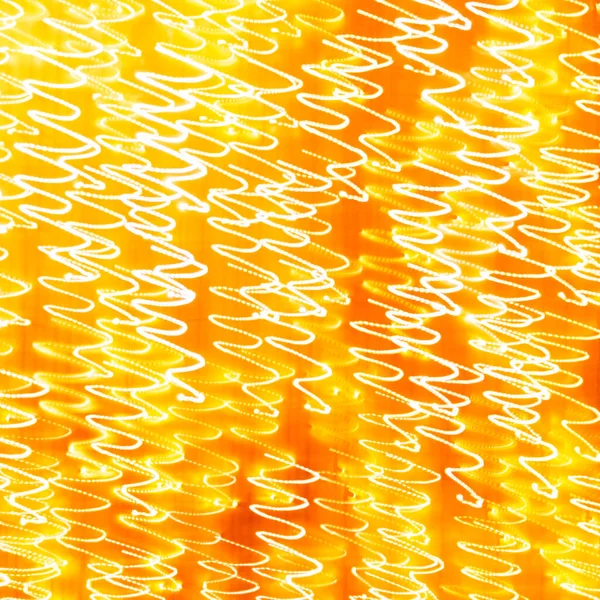 Feestelijke abstracte textuur achtergrond. Witte krullen op een gele en oranje achtergrond. Zwenkpatroon. Kerstverlichting — Stockfoto