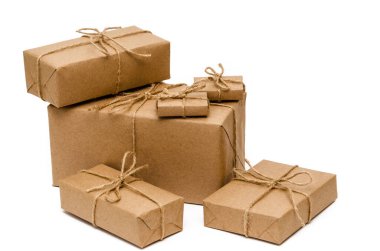 Kahverengi kraft kağıdıyla sarılmış ve beyaz arka planda sicimle bağlanmış yığınla kutu. Teslimat, taşınma, paket ve hediye konsepti. Yakın plan.