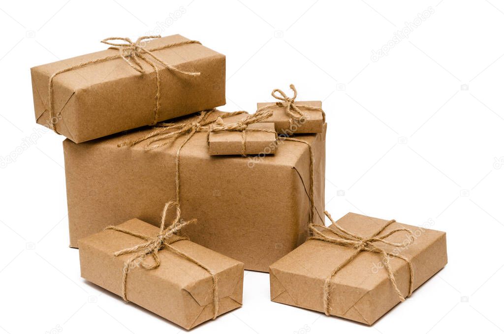 Pile of stacked boxes wrapped with brown kraft paper and tied with twine on a white background. Delivery, moving, package and gifts concept. Close-up