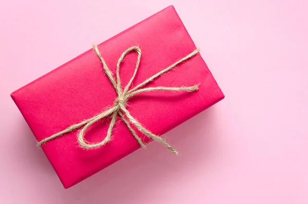 粉色礼品盒，用线绑在浅粉色的背景上。 假期的概念。 死了现在的想法。 平躺在床上 复制空间 — 图库照片