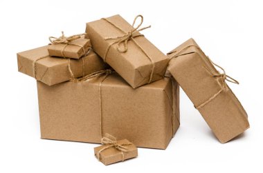 Kahverengi kraft kağıdıyla sarılmış ve beyaz arka planda sicimle bağlanmış yığınla kutu. Yakın plan. Teslimat, taşınma, paket ve hediye konsepti