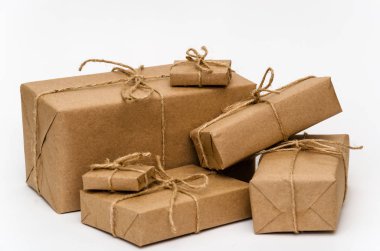 Kahverengi kraft kağıdıyla sarılmış ve beyaz arka planda sicimle bağlanmış yığınla kutu. Lojistik ve paket konsepti. Yakın plan.