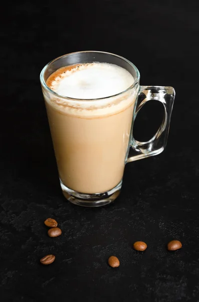 Verre de café avec du lait sur fond noir. Latte chaude ou cappuccino dans une tasse transparente. Boisson du matin. Gros plan — Photo