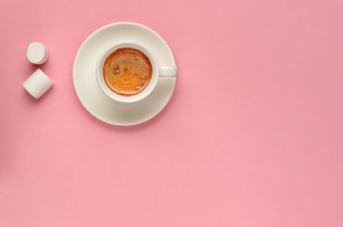 Yaratıcı düz beyaz kahve fincanı ve iki tane de milenyum pembesi arkaplan şekeri. Asgari düzeyde. Uzayı kopyala, üstten bak, üstten bak. Kadınsı blog, sosyal medya, ağlar için maket