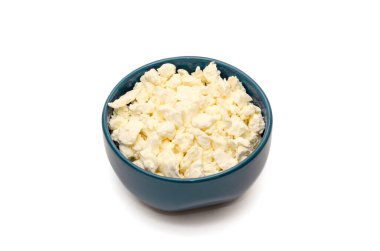 Beyaz arka planda mavi seramik kasede taze organik süzme peynir. Sağlıklı süt ürünleri kavramı. Protein zengini yiyecekler. - Yakın çekim. Boşluğu kopyala