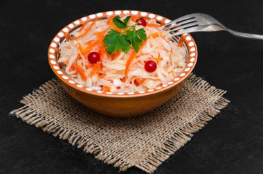 Siyah arka planda havuçlu ev yapımı lahana turşusu. Mayalanmış gıda, doğal probiyotik. Sağlıklı beslenme ve beslenme konsepti. Kırsal tarzda. Yakın çekim.