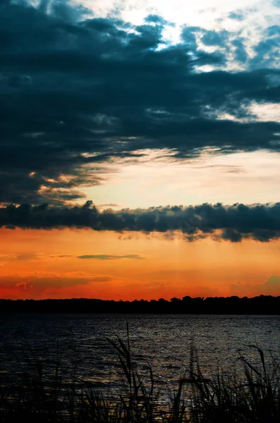 Pôr do sol no céu dramático vermelho sobre o rio. Crepúsculo de verão — Fotografia de Stock