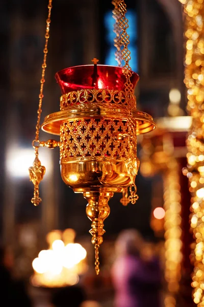 Hanging icon lamp of transparent red glass in golden holder in Orthodox church. Gilded church altar utensil. Religious concept. Closeup — Stock Photo, Image