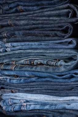 Farklı tonlarda kot pantolon yığını. Kot pantolon arka planı. Yakın plan. Yumuşak odak