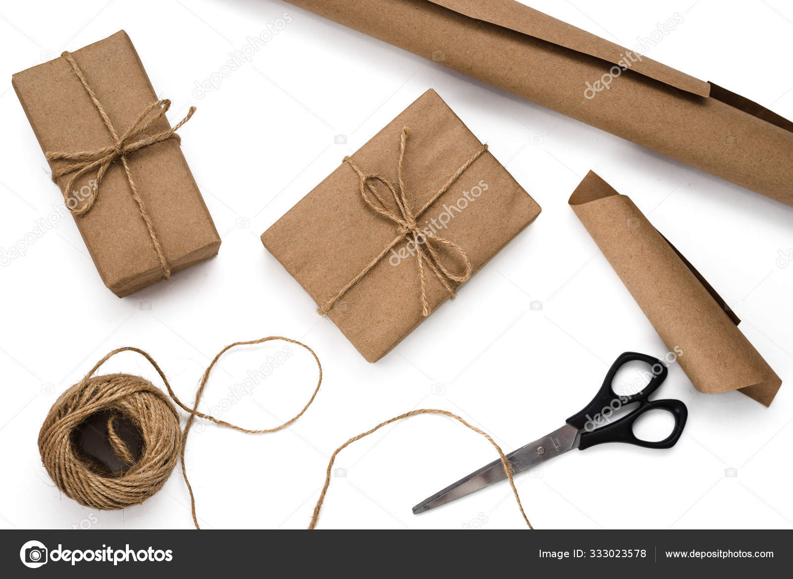 Gift box Wrapped in Brown Recycled Paper with White Ribbon Bow Top View  with Fir Branches. Christmas Concept. Close Up. Stock Photo