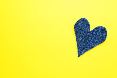 Sarı arka planda mavi kot bir kalp. Tebrik kartı için bir model. Boşluğu kopyala