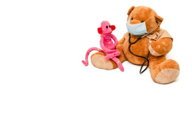 Tıbbi maskeli oyuncak ayı steteskopla pediyatrist ve şirin maymun olarak beyaz arka planda izole edilmiş hasta olarak sunuldu. Çocuk doktoru konsepti. Doktor hasta ilişkisi. Metin için boşluk
