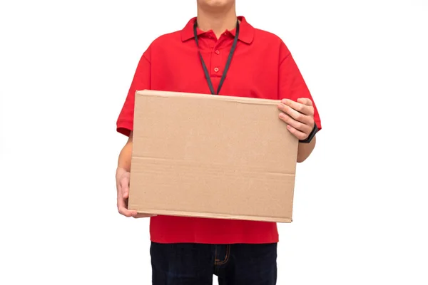 Junger Lieferkurier in rotem T-Shirt mit Namensschild, Karton mit Bestellung auf weißem Hintergrund. Nahaufnahme. Lieferservice und Logistikkonzept. Kopierraum — Stockfoto