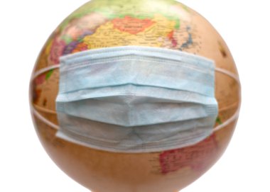 Globe in protective medical mask isolated on white background. Novel rapidly spreading Coronavirus, 2019-nCoV epidemic. Coronavirus outbreak control concept. Focus on mask.