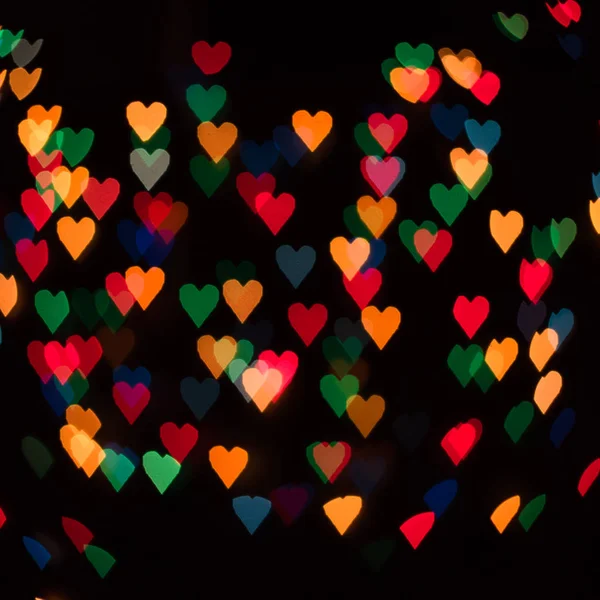 Odaklanamayan soyut çok renkli kalp şeklindeki bokeh ışıkları arka plan. Sevgililer Günü, Noel konsepti. — Stok fotoğraf