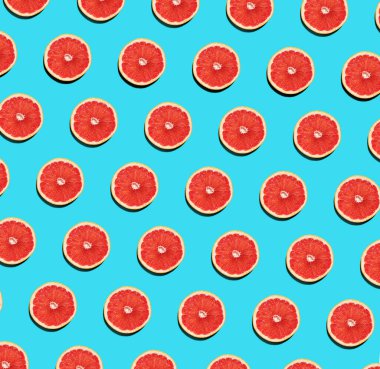 Mavi arka planda taze greyfurt dilimlerinin meyve deseni. Soyut yaz meyvesi arka planı. Düz yatıyordu. Üst görünüm