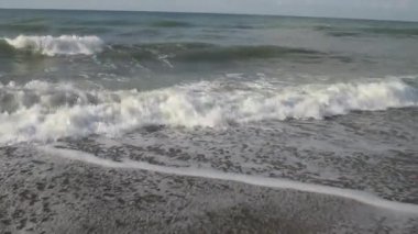 Tropik denizlerde yazın kumlu sahilde beyaz köpüklü büyük dalgalar.