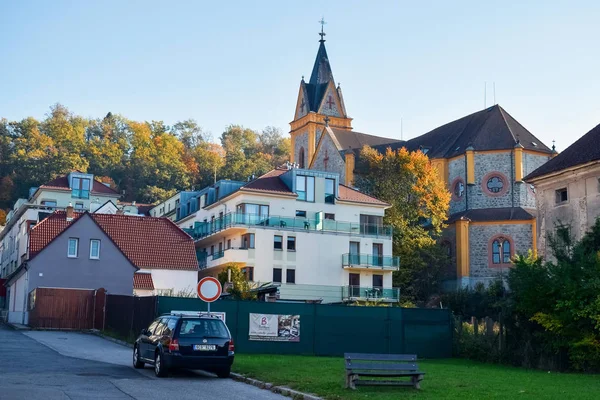 PRAGA, REPÚBLICA CHECA - OKTOBER 11, 2018: Antigua iglesia y una casa moderna en Europa y hojas amarillas en los árboles — Foto de Stock