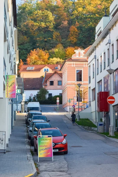 PRAGA, REPUBBLICA CECA - 11 OTTOBRE 2018: Strada stretta in città con auto parcheggiate e pubblicità con albero autunnale — Foto Stock