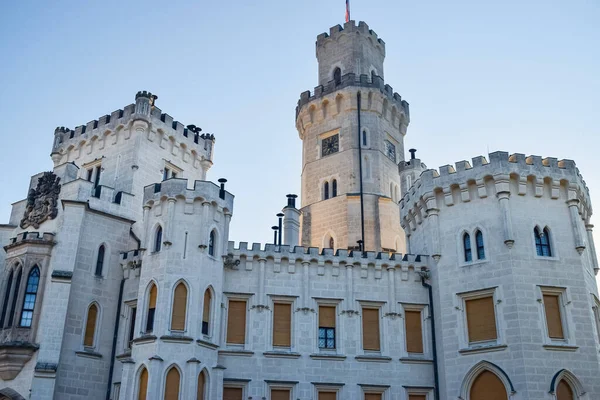 Tower of ancient European castle with clock and windows and battlements on roof for defense — Stock Photo, Image