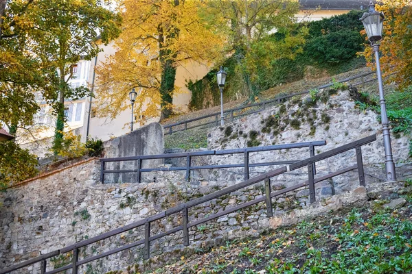 Escalera en el parque con barandilla de madera y linternas antiguas con paredes de piedra en otoño —  Fotos de Stock