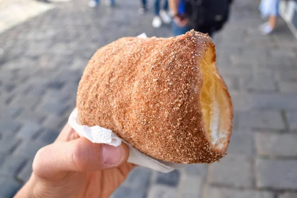 Hand met verse gebak en suiker op straat in Praag — Stockfoto