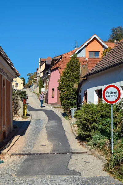 PRAGA, REPUBBLICA CECA - 11 OTTOBRE 2018: Un uomo solitario cammina lungo una stretta strada tra case in Europa con cartello stradale — Foto Stock