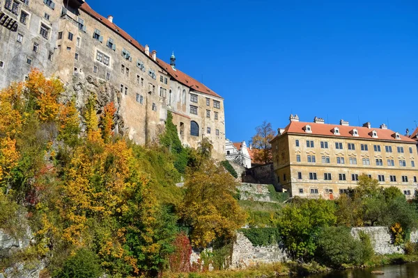 Ancient buildings on the edge of a cliff with brown roofs and colored leaves on trees in Czech Republic in autumn — Stock Photo, Image