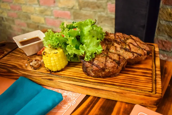Szaftos marhahús zöldsalátával és szósszal az étteremben — Stock Fotó