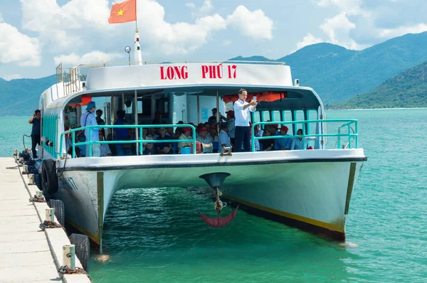 NHA TRANG, VIETNAM - APRIL 18, 2019: A tourist makes photo in a boat with an anchor at a pier in tropics