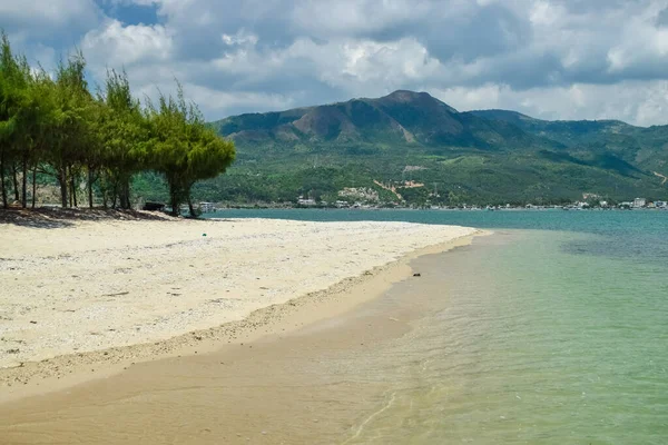 Tropikal adada dağları olan boş kumlu bir sahil.