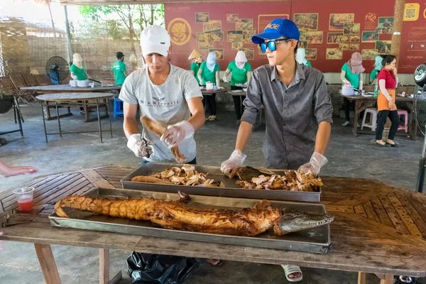 NHA TRANG, VİETNAM - 19 Nisan 2019: İnsanlar restoranda masada et ve kızarmış timsah kesiyor