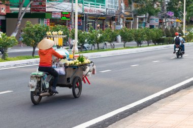 NHA TRANG, VİETNAM - 20 Nisan 2019: Motosikletli kadın haşlanmış mısır arabasını pazara taşıyor