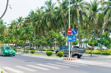 NHA TRANG, VİETNAM - 20 Nisan 2019: Yol boyunca arabalar ve yol işaretli palmiye ağaçları