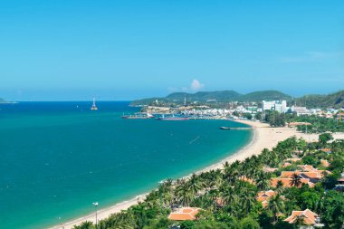 Sahilde ve dağlarda kayıklar ve palmiye ağaçları olan deniz koyuna.