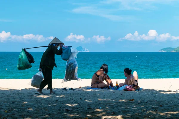 NHA TRANG, VİETNAM - 21 Nisan 2019: Deniz ürünleri tüccarı ve turistler denizin kumlu sahillerinde
