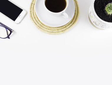 Kahve fincanı, bardak ve telefonlu beyaz ofis masası. Üst görünüm, kopyalama alanı.