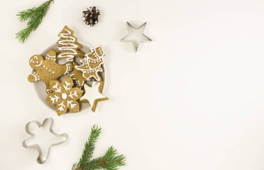 Hafif arka planda bir tabakta zencefilli çörek, Noel ağacı dalı, külah. Noel için yemek konsepti.