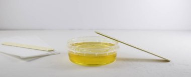 Kavanozda şeker ezmesi, ahşap bir spatula ve tüy dökücü için şeritler. Saç kesimi, tüy dökümü..